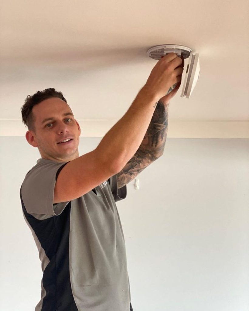 Employee working at smoke alarm installation